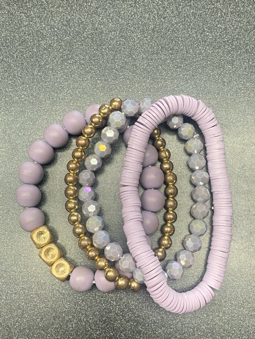 Set of four purple and gold stackable bracelets.